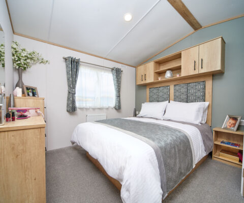 Master bedroom in soft colours with overhead storage