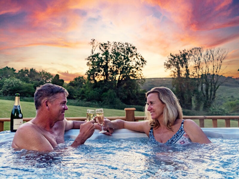 Couple in hot tub with stunning sunset