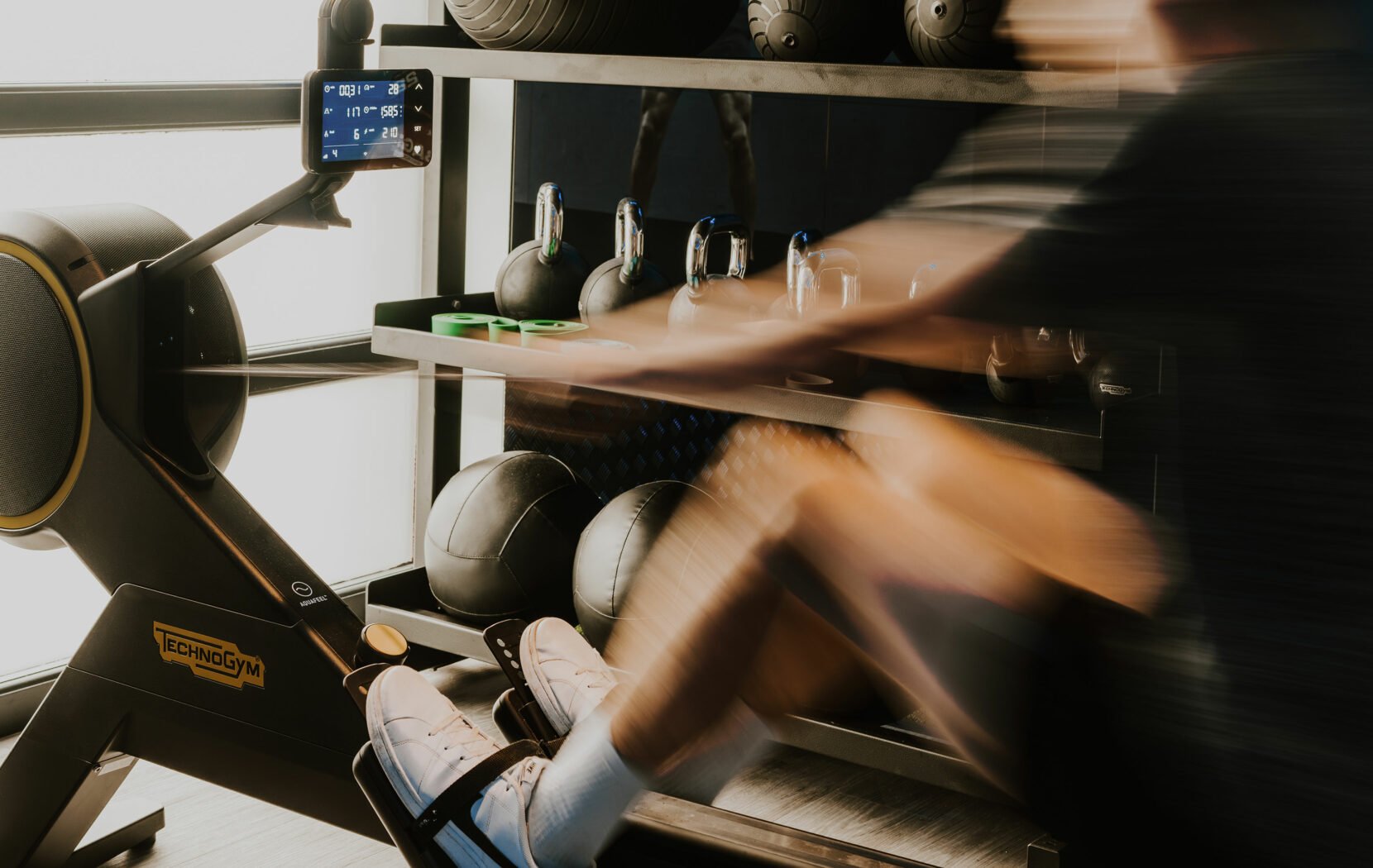Man rowing on Technogym rower in a gym